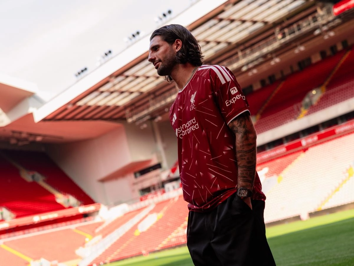 Dominik Szoboszlai posing in a Liverpool jersey at Anfield
