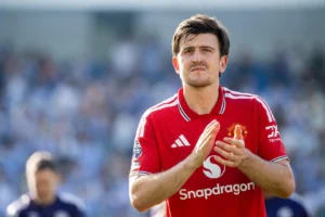 Harry Maguire applauding Manchester United fans in a stadium