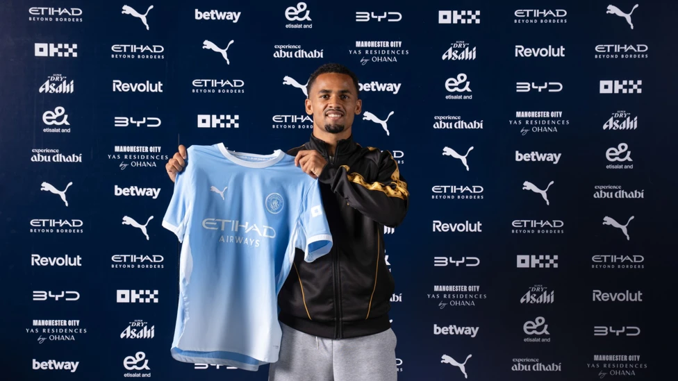 Iliman Ndiaye posing in a Manchester City shirt