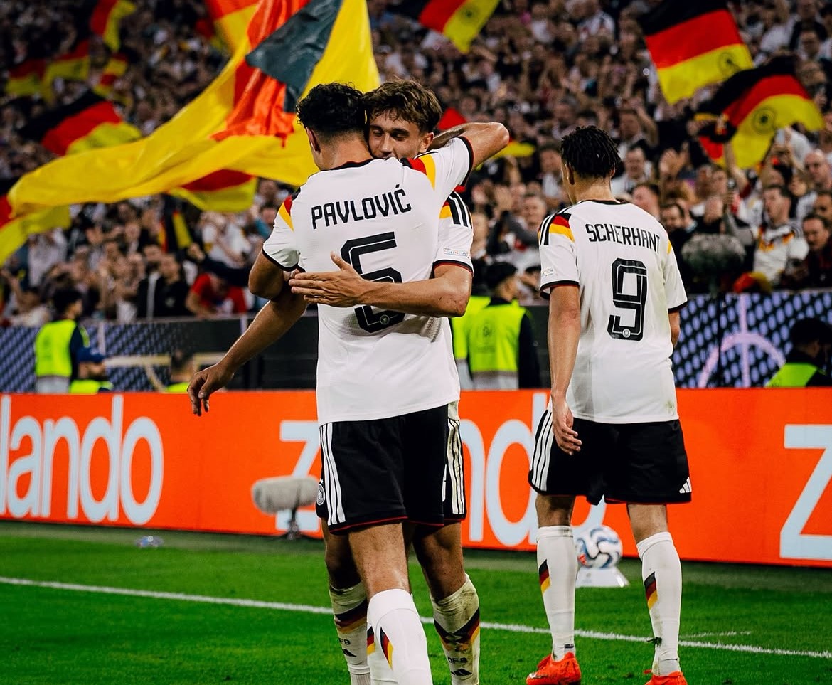 Aleksander Pavlovic giving Tom Bischof a hug after the latter scores on Germany debut