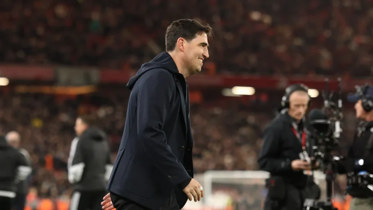 Liverpool coach Andoni Iraola walking in a suit at Anfield