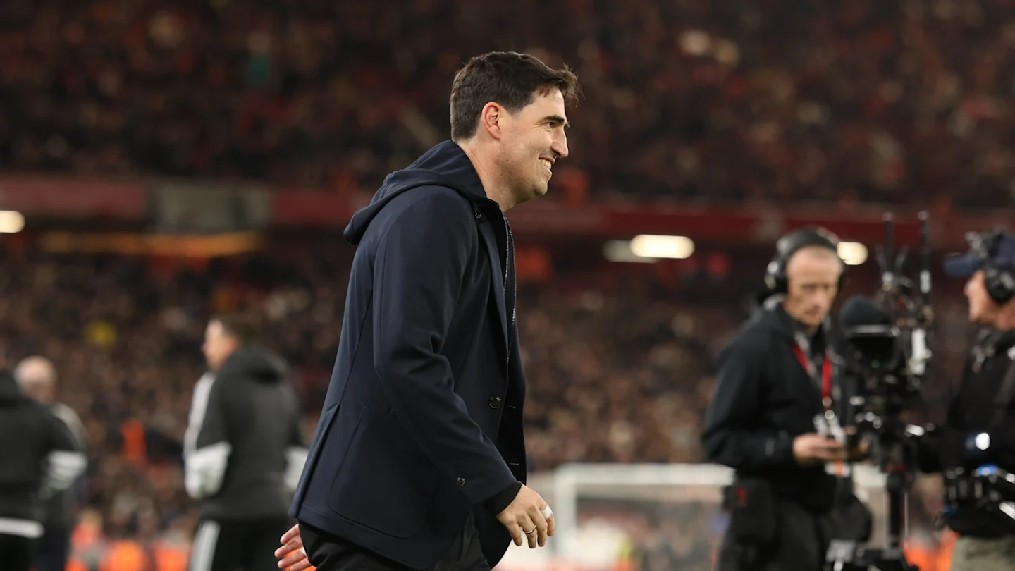 Liverpool coach Andoni Iraola walking in a suit at Anfield